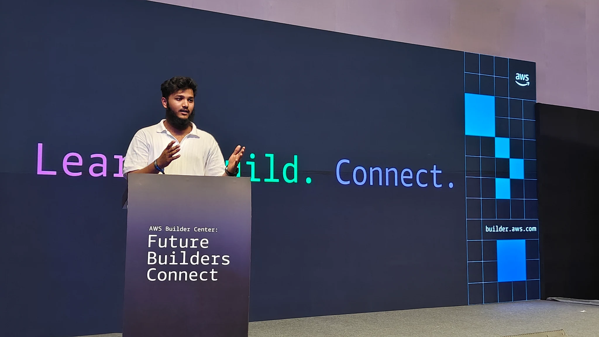 Mahaboob Ashraf presenting at AWS Builder Center, gesturing with both hands